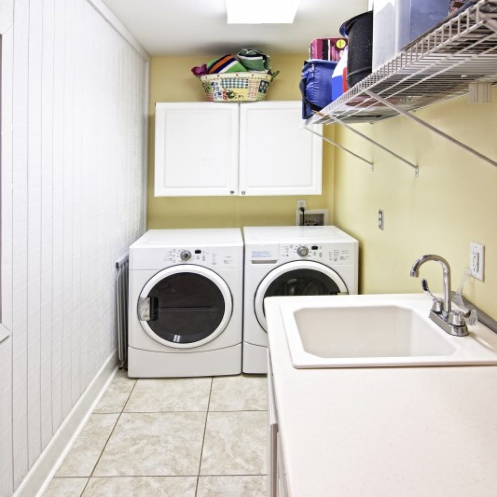 Laundry room with washer and dryer awaiting service, illustrating common household appliances that can impact appliance repair cost.