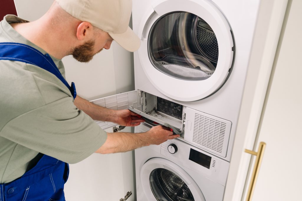 Skilled technician performing professional appliance repair on a washing machine, carefully inspecting and fixing its components.